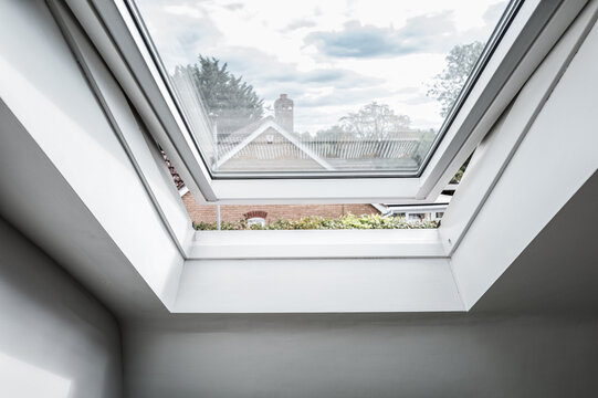 Newly installed skylight window seen in a loft conversion for a former bungalow. The skylight is seen open, allowing fresh air into the new first floor room.
