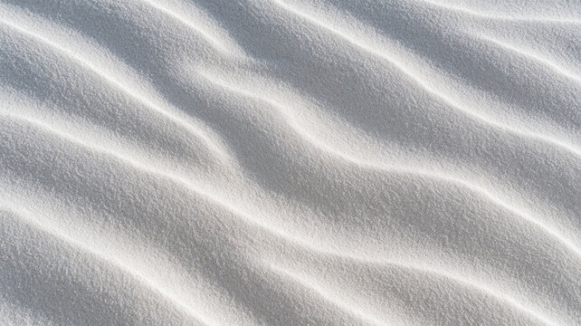 White sand ripples forming natural wave patterns across the frame, highlighting the subtle texture and serene simplicity of desert or beach environments