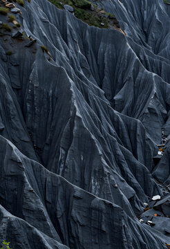 Geological erosion and climate change, rugged dark slate mountain landscape with sharp ridges and deep ravines in a natural wilderness environment