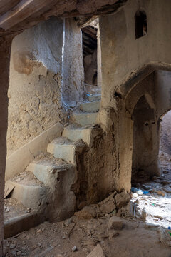 Crumbling mud-plastered staircase winding upward inside a ruined house, Ad Dakhiliyah Region, Al Hamra, Oman