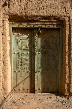 Ornately carved wooden double door secured with a padlock, Ad Dakhiliyah Region, Al Hamra, Oman