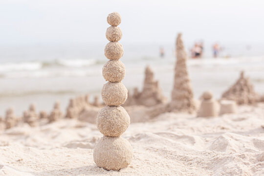 Sandkugeln bauen. Turm aus Sandkugeln. Aktivit&auml;t am Sandstrand.