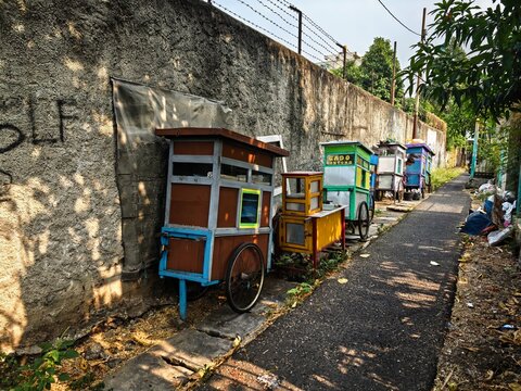 Traditional Indonesian street food carts lined up along a wall