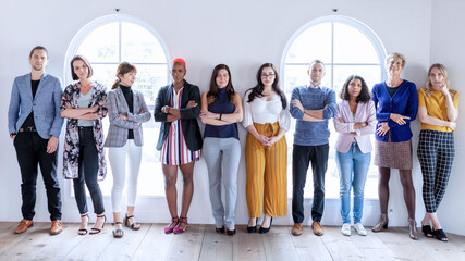 Fototapeta premium Diverse group of men and women standing together in a bright studio
