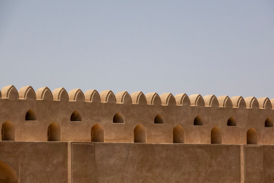 Close-up of the crenellated battlements and arrow slits along the walls of Nizwa Fort, Ad Dakhiliyah Region, Nizwa, Oman