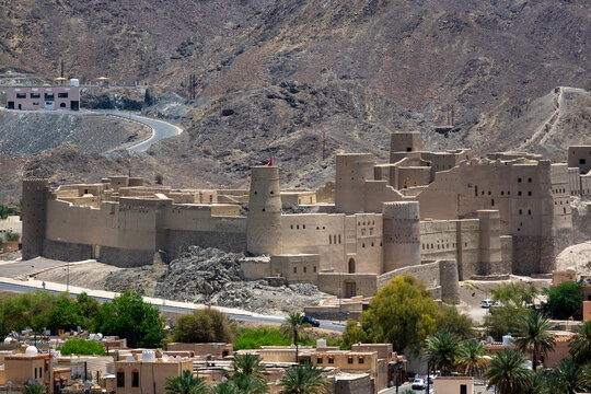 Telephoto view of Bahla Fort's mudbrick towers and walls set against the mountains, Ad Dakhiliyah Governorate, Bahla, Oman