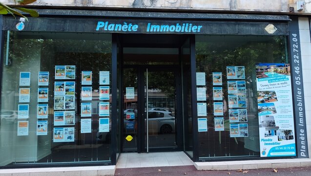 Royan, France - July 15, 2026: Charente-Maritime. Nouvelle-Aquitaine. Real estate agency storefront with multiple property listings displayed in windows, featuring Planete Immobilier signage