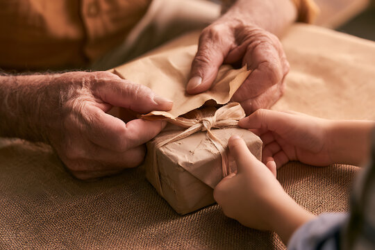 Grandparents and grandchildren share moments of joy while unwrapping a gift together on Grandparents Day