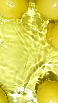 Yellow water background with fresh whole lemons on edges and space for text