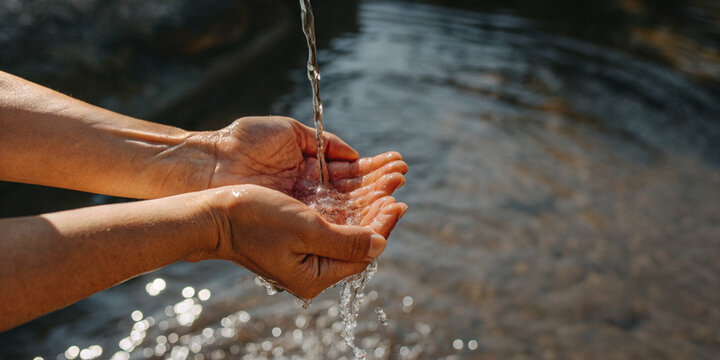 Lifestyle Natural Wellness. Water conservation and environmental protection with human hands holding the clean water flowing down from above