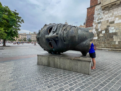 Krakow, Poland, July 26, 2025: Old Town in Krakow. Main Market Square with the statue of a young man's head bound: Eros Bendato (Eros Bound)
