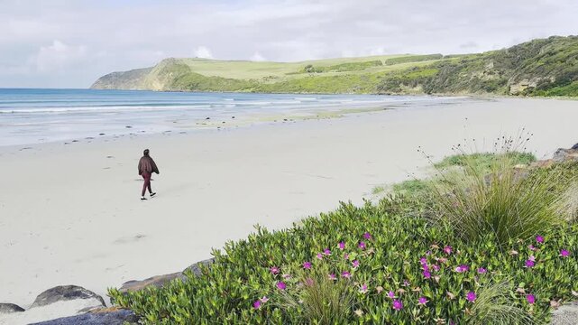 joyful girl walks along Bridgewater Bay Beach, with its striking white sand and turquoise ocean water, one of the most scenic beaches on Victoria's Discovery Coast, near Portland, Victoria, Australia