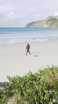 joyful girl walks along Bridgewater Bay Beach, with its striking white sand and turquoise ocean water, one of the most scenic beaches on Victoria's Discovery Coast, near Portland, Victoria, Australia