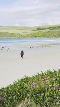 joyful girl walks along Bridgewater Bay Beach, with its striking white sand and turquoise ocean water, one of the most scenic beaches on Victoria's Discovery Coast, near Portland, Victoria, Australia