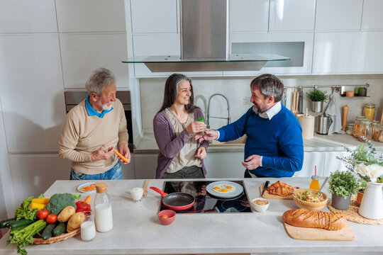 Family cooking healthy breakfast together in kitchen