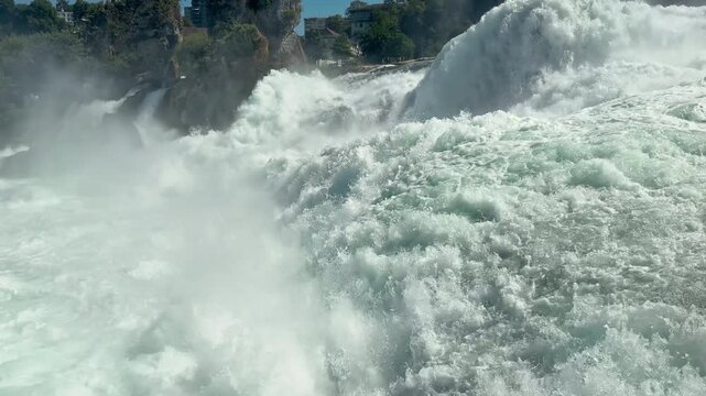 Foaming Rhine Falls fills the frame with turbulent turquoise water outdoors, Close waterfall footage emphasizes spray movement and immense river power
