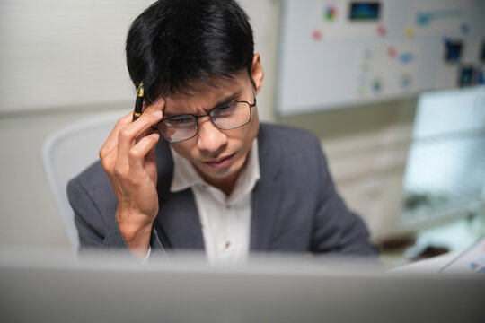 Stressed Businessman Thinking at Office Desk