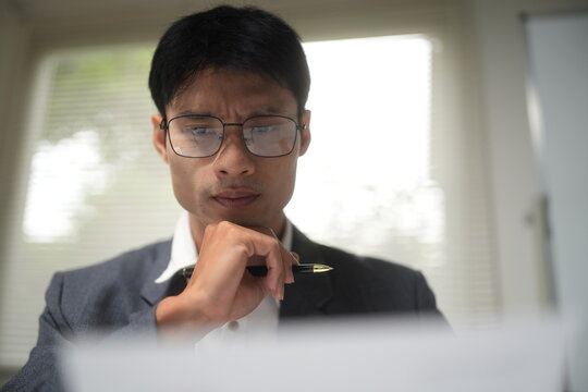 Thoughtful Businessman Working on Laptop in Office