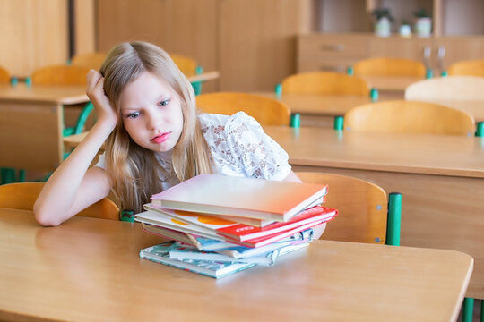 Student at school desk looks worried about studying and school work during a classroom session
