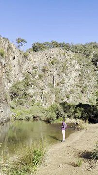 A girl hiker stands and admires the Werribee River during the challenging Werribee Gorge Circuit Walk &mdash; one of the best trails near Melbourne, Victoria, Australia.

