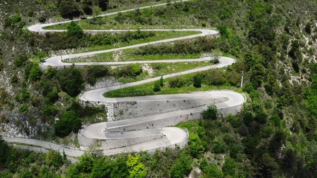 Aerial drone view of cyclist riding on winding mountain road near &Egrave;ze, French Riviera, France