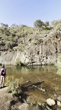 A girl hiker stands and admires the Werribee River during the challenging Werribee Gorge Circuit Walk &mdash; one of the best trails near Melbourne, Victoria, Australia.
