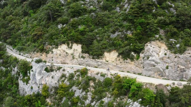 Aerial drone view of cyclist riding on mountain road near &Egrave;ze, French Riviera, France