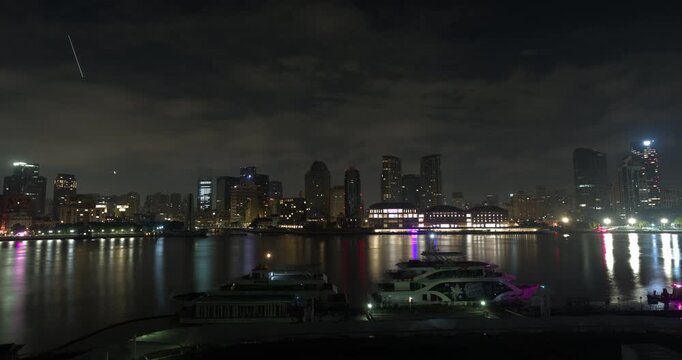 SHANGHAI, CHINA - AUGUST 23, 2026: Docked cruise boats sit at the waterfront as the North Bund skyline transitions from night to morning in SHANGHAI, China, in timelapse