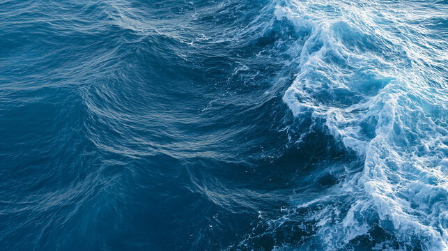 Close up of deep blue ocean waves with white frothy foam and ripples.