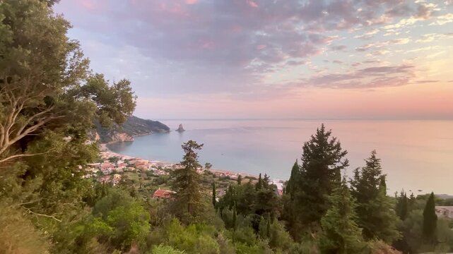 Panoramic sunset view of Agios Gordios bay and Ortholithi rock in Corfu, Greece