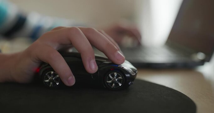 Close-up caucasian children hand use computer mouse controller. Boy use laptop. 4K 10-bit