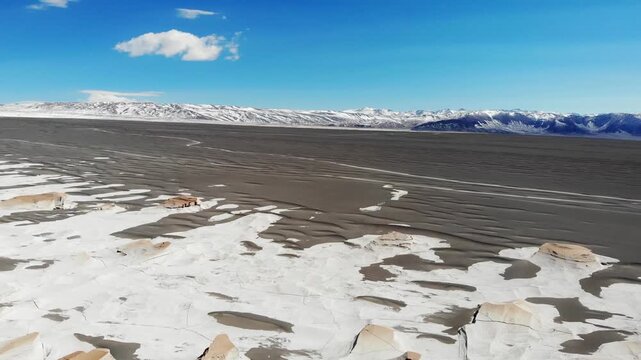 Cinematic push in drone footage flying above the remarkable pumice field of Campo de Piedra Pomez, Catamarca, surrounded by Andean scenery.