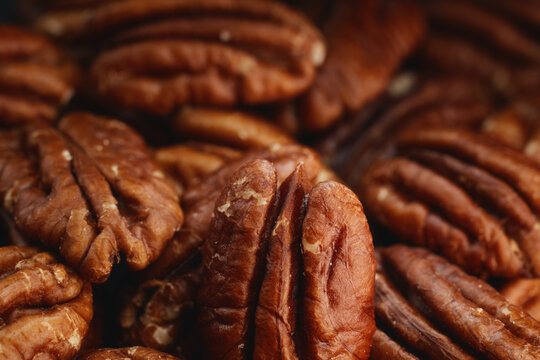 Extreme macro shot of fresh premium pecan nuts filling the frame with selective focus with artistic lighting. Perfect for healthy eating, gourmet food, culinary, and dietary content.