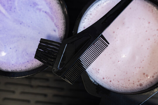 Mixing hair dye colors in bowls with a comb for a hair coloring process
