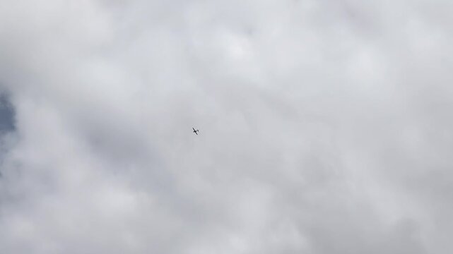 Light aircraft flying through clouds on a bright day