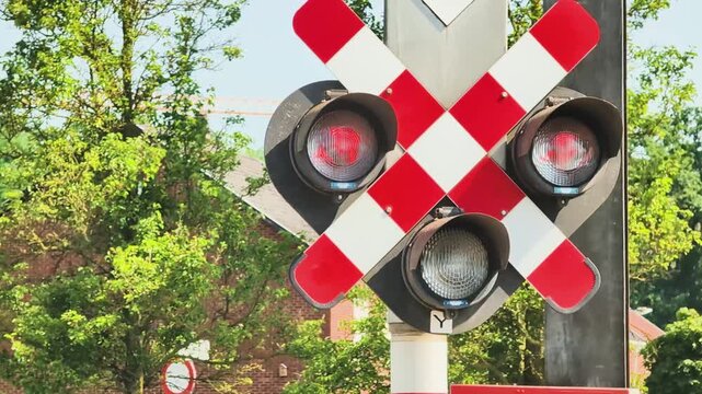 Railroad crossing signals change with light patterns in a busy area