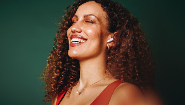 The woman finds calm with technology and earbuds in a close-up portrait