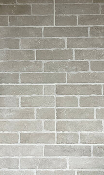 Pared de ladrillos vistos en tonos grises y cemento blanco con textura r&uacute;stica y estilo industrial moderno