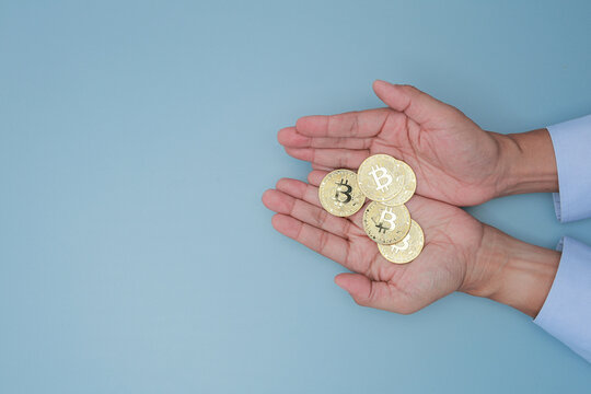 Businessman hand holding golden coin showing crypto asset management with confident hope for modern financial wealth and security
