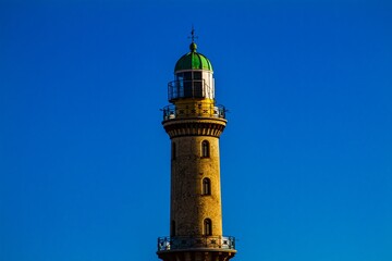 Obraz premium Historic lighthouse against a clear blue sky