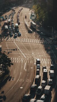 Vehicles navigate a bustling urban intersection with visible lanes and traffic signals during daylight hours. Time-lapse, Seoul, South Korea