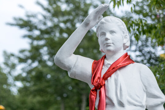 White statue of a young pioneer saluting with a red neckerchief
