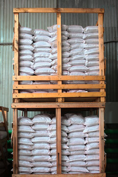Storage of agricultural products in warehouse in bags. Bags are stacked. Wooden boxes in warehouse. Industrial storage of packaged products