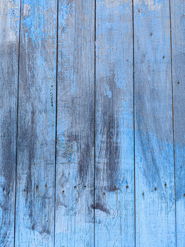 Grunge Wooden Surface with Peeling Blue Paint and Visible Wood Grain Background.
