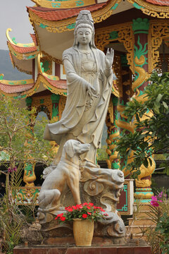 Stone Guanyin statue sitting on lunar zodiac dog mount, traditional Asian astrology faithful hound sculpture for loyalty and protection