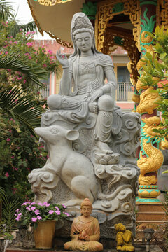 Stone Guanyin statue sitting on lunar zodiac rat mount with miniature Buddha figurine, traditional Asian astrology and prosperity concept