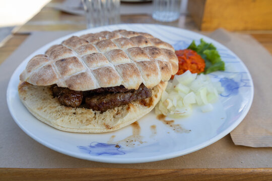 serbian cevapcici in flatbread with onion and ajvar