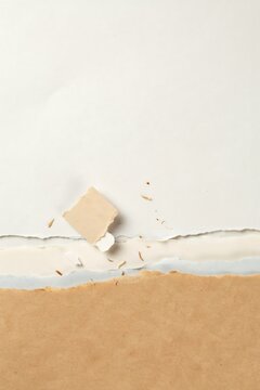 Torn paper texture with layered edges of white and brown cardboard, abstract background, with ripped paper, strips and rough, paper fiber details.