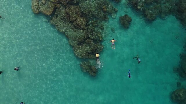 Aerial drone view of isolated rocky islet and coral reef in deep blue sea, Redang Island, Malaysia