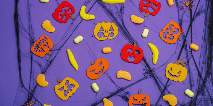 Funny Halloween background. Scary spider web, traditional fall pumpkins, bats and spiders